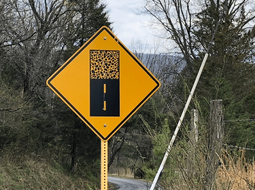 A yellow sign on a pole

Description automatically generated