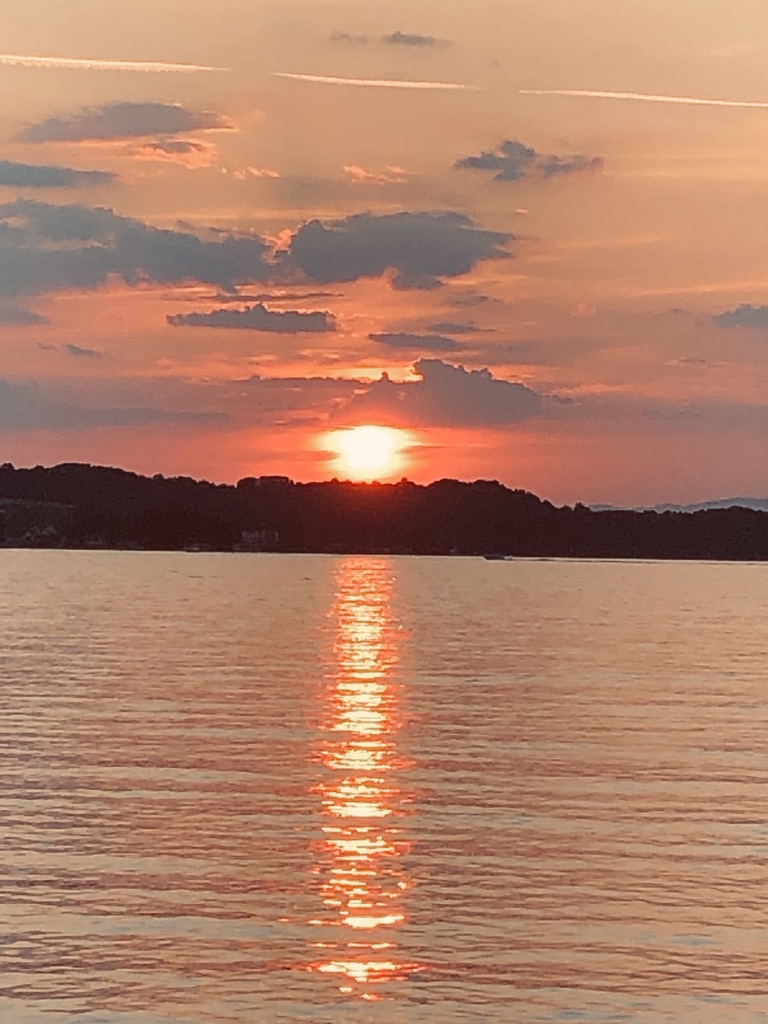 A sunset over a body of water

Description automatically generated