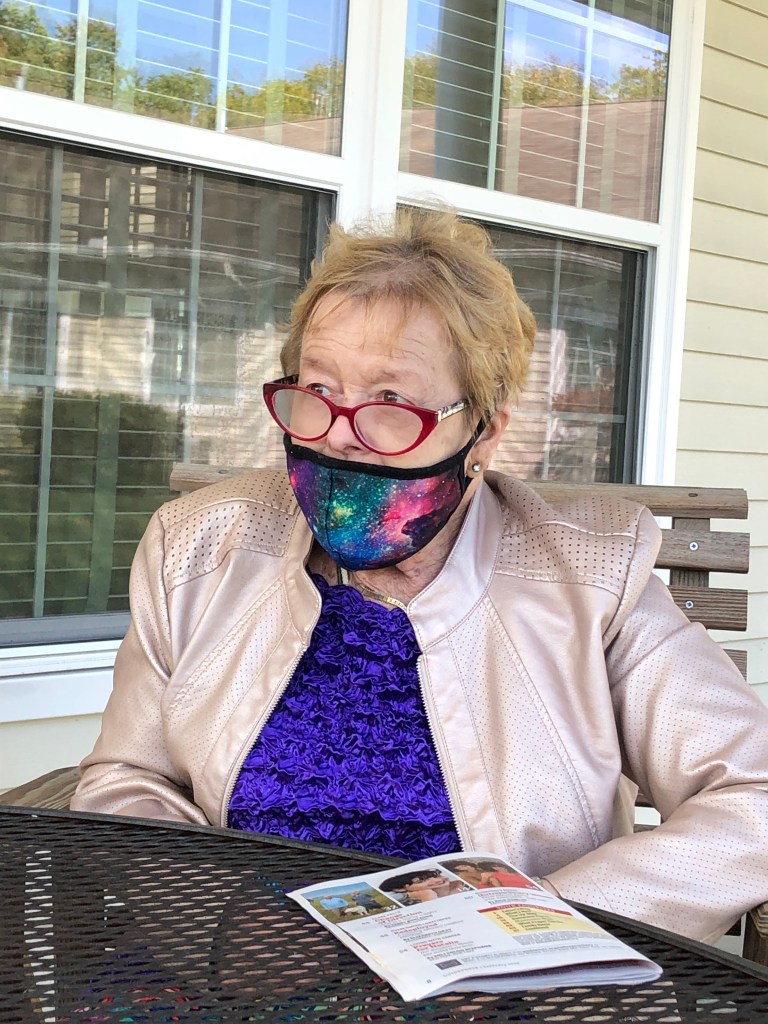 A person sitting at a table in front of a window

Description automatically generated